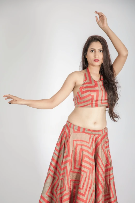 a woman in a skirt posing for a picture, orange halter top, anjali mudra, pose reference, beige