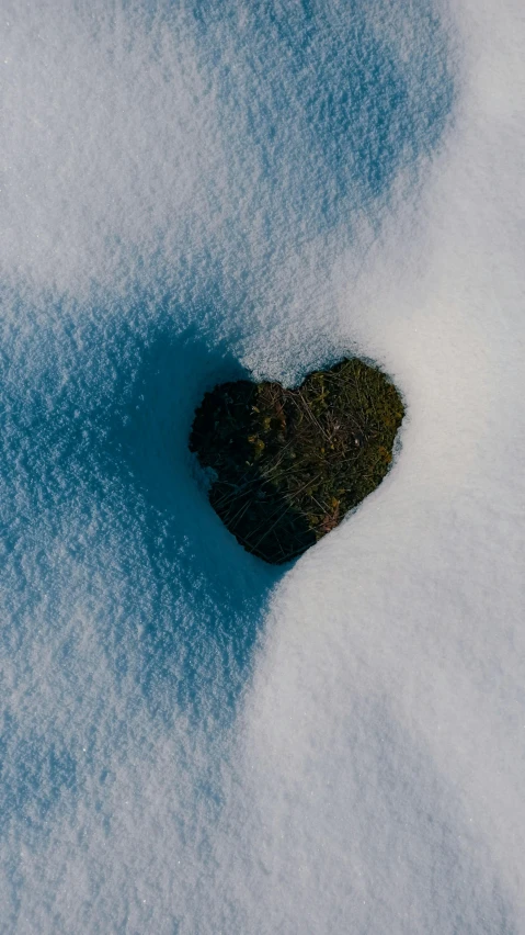 a heart shaped rock sitting in the snow, an album cover, unsplash, aerial, 268435456k film, no words 4 k, simplistic