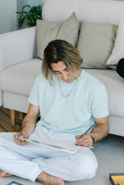 a man sitting on the floor reading a book, a drawing, pexels contest winner, wearing a light blue shirt, liam brazier and nielly, mid long hair, on a white table