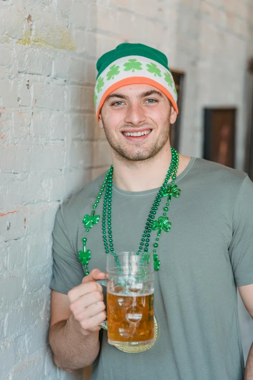 a man holding a glass of beer in front of a brick wall, green tiara, pots of gold, orange head, french man from louisiana