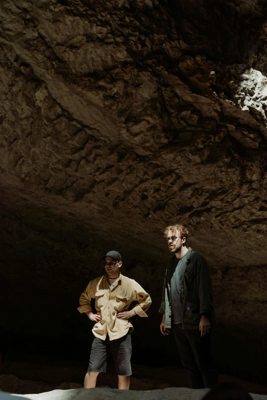 a couple of men standing next to each other in a cave, ben watts, limestone, production photo, explorer