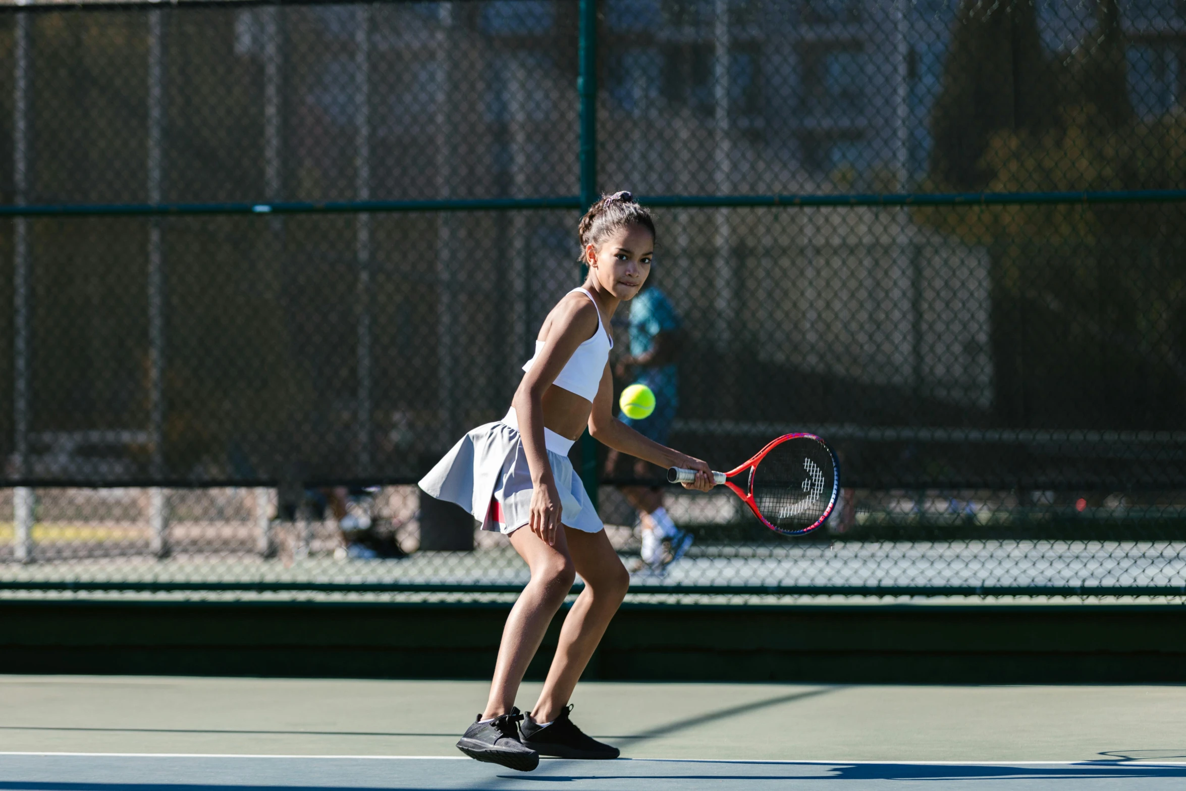 a woman holding a tennis racquet on a tennis court, unsplash, happening, girls, isabela moner, performing, wearing jacket and skirt