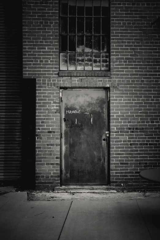 a black and white photo of a door in a brick building, by Andrew Domachowski, factory floor, medium format. soft light, unknown, back alley