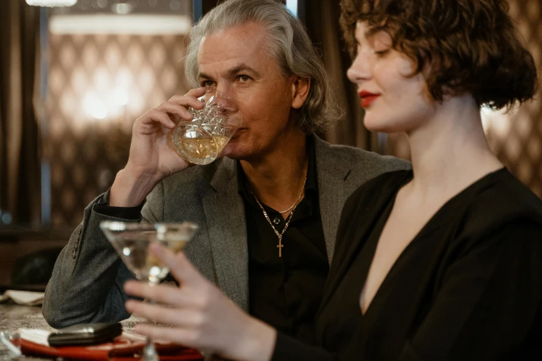 a man and a woman sitting at a table drinking wine, pexels contest winner, a silver haired mad, speakeasy, profile image, liquid gold