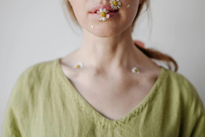 a close up of a woman with flowers on her face, inspired by Elsa Bleda, trending on pexels, chamomile, wearing collar on neck, eating, full body image