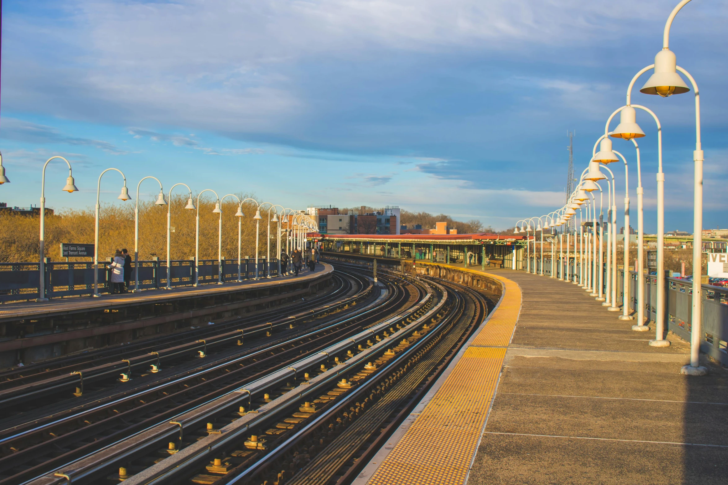 a train traveling down train tracks next to a train station, by Carey Morris, unsplash, art nouveau, harlem, panoramic, bridges and railings, 2000s photo