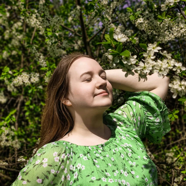 a woman standing in front of a blooming tree, by Anna Füssli, pexels contest winner, realism, glowing green, relaxed pose, portrait of a young teenage girl, sigma 85/1.2 portrait