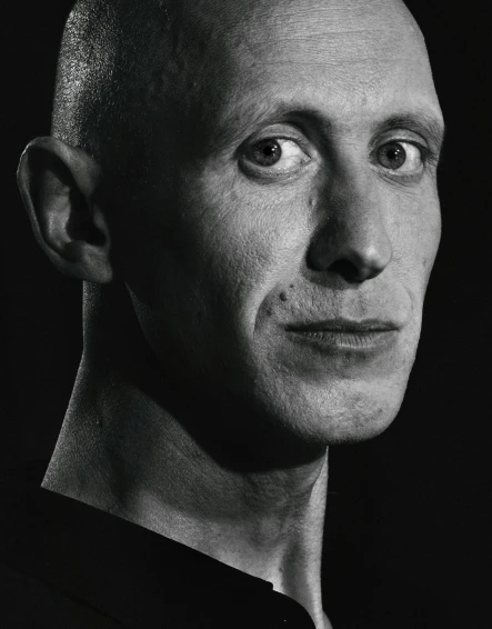 a black and white photo of a bald man, a character portrait, inspired by Graham Forsythe, unsplash, portrait of chester bennington, john waters, showstudio, hard rubber chest