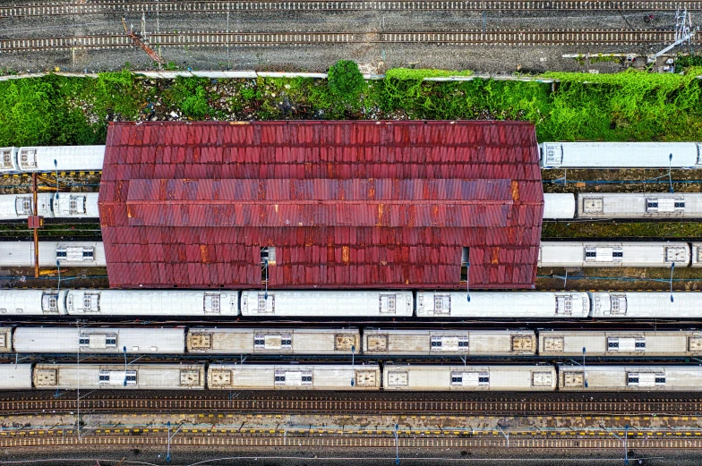 a red roof sitting on top of a train track, inspired by Andreas Gursky, pexels contest winner, photorealism, dji top down view, overgrown city, panoramic shot, jakarta