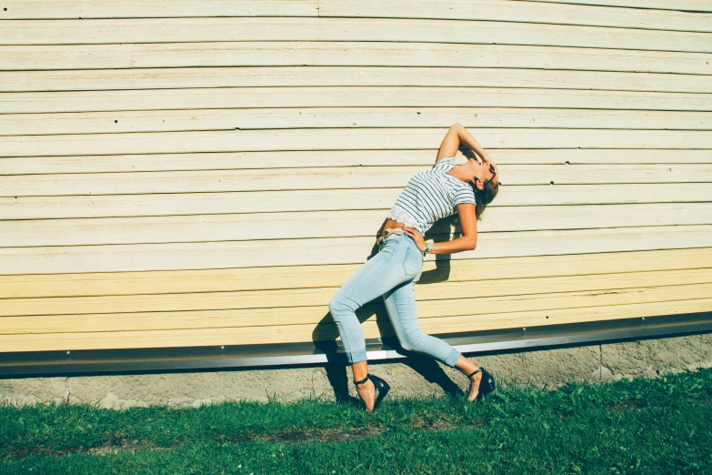a woman leaning against a wall in front of a house, inspired by Balthus, pexels contest winner, happening, jeans and t shirt, dynamic dancing pose, crazy angle, 15081959 21121991 01012000 4k