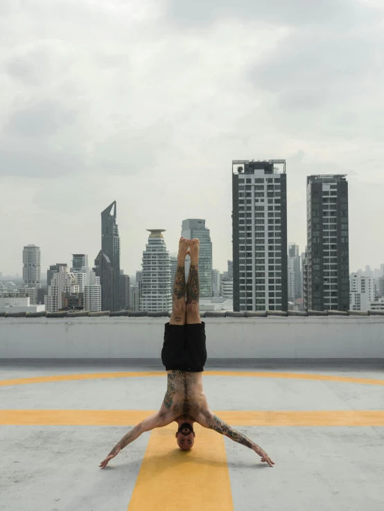 a man doing a handstand on top of a roof, pexels contest winner, brutalism, bangkok, yoga meditation pose, square, low quality photo