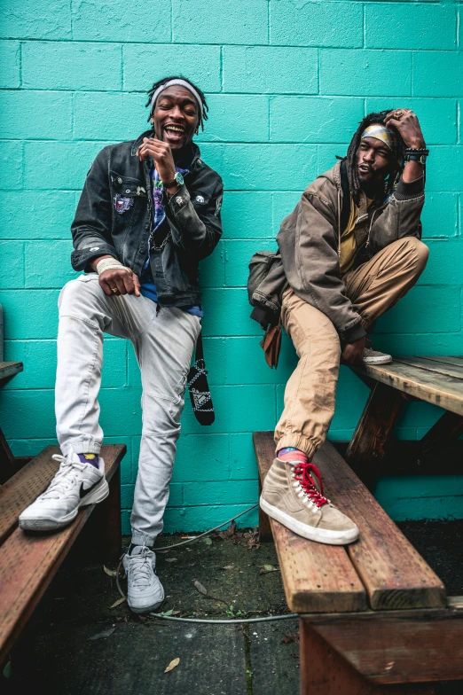 two men sitting next to each other on benches, a portrait, trending on pexels, graffiti, dreads, jean and multicolor shoes, promotional image, ( ( dark skin ) )