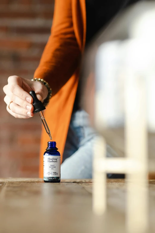 a woman is opening a bottle of essential oil, by Matthias Stom, unsplash, sitting on a desk, hanging, thumbnail, hero shot