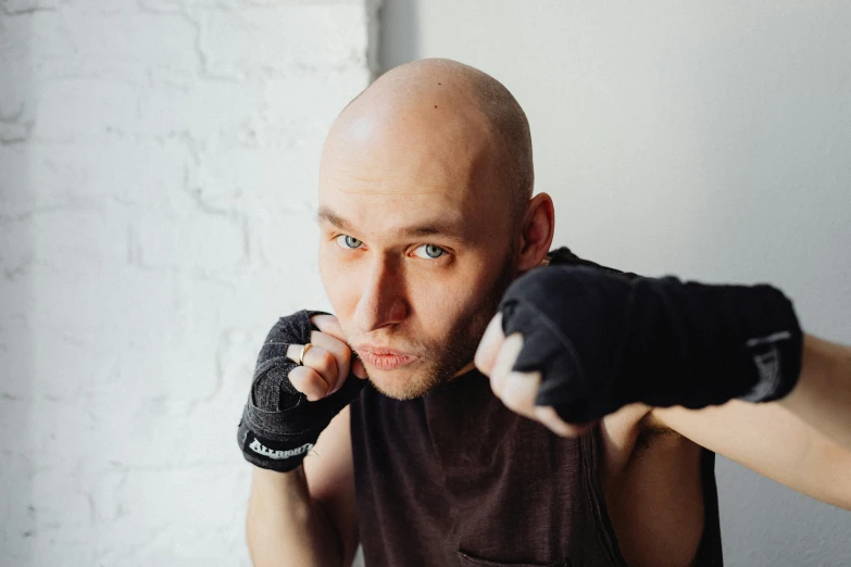 a close up of a person wearing boxing gloves, a portrait, by Ilya Ostroukhov, no hair completely bald, avatar image, instagram picture, battle pose