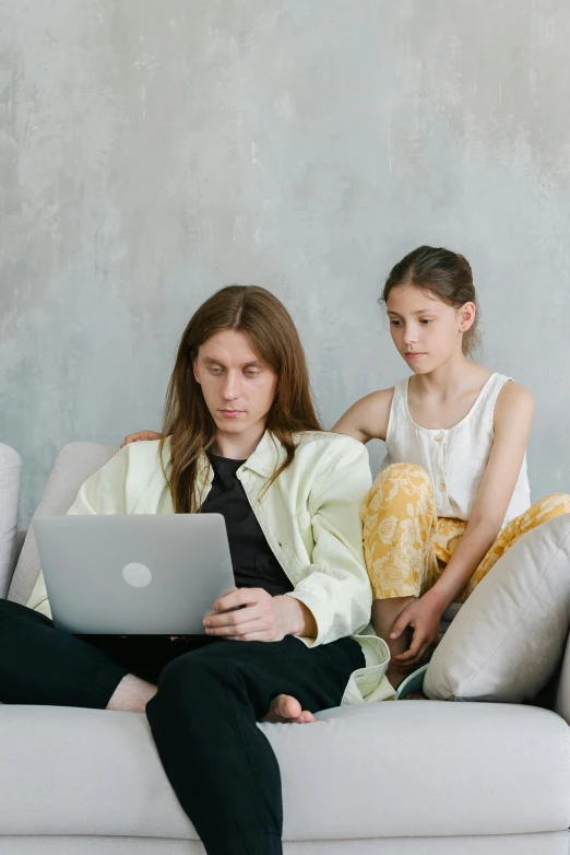 a man and a woman sitting on a couch with a laptop, by Carey Morris, trending on pexels, greta thunberg, young with long hair, with a kid, sad man