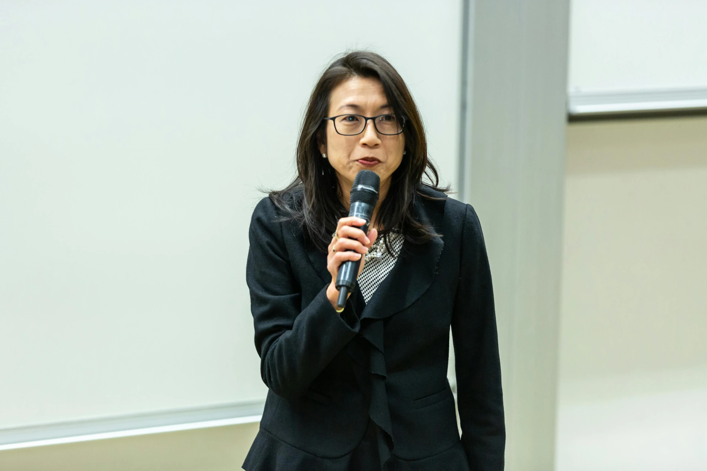 a woman in a suit speaking into a microphone, shin hanga, teaching, unblur, portrait image, keng lye