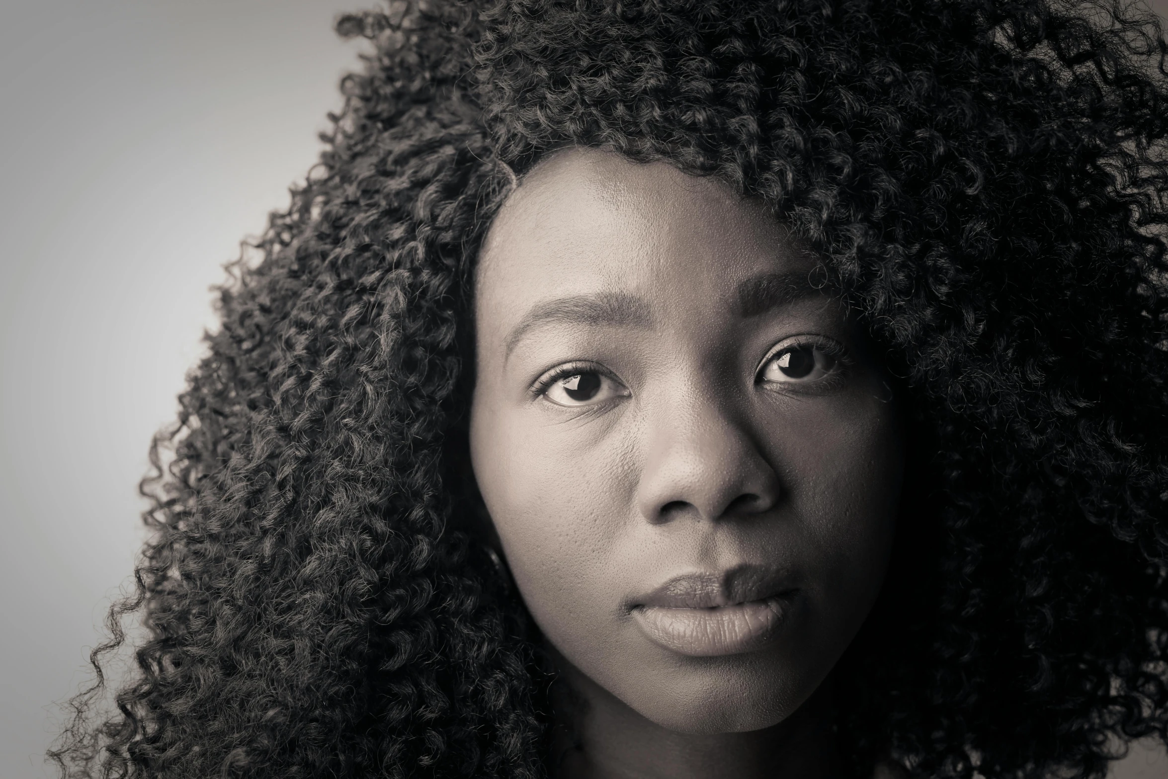 a black and white photo of a woman with curly hair, by Lily Delissa Joseph, pexels contest winner, hyperrealism, african facial features, color photograph portrait 4k, sza, multiple stories