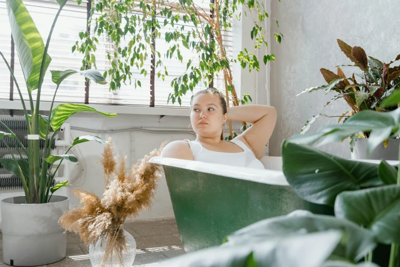 a woman sitting in a bathtub surrounded by plants, pexels contest winner, looking to the right, thicc build, profile image, eucalyptus