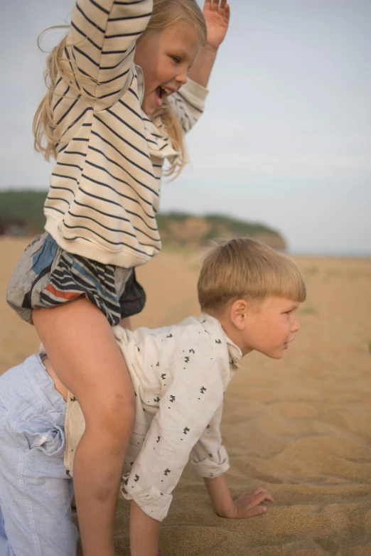 a little boy and a little girl playing in the sand, unsplash, shirt, stacked image, seaside, detail shot