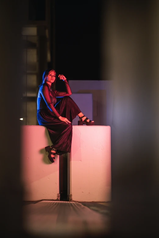 a woman sitting on top of a white wall, by Matt Cavotta, shot at night with studio lights, fashion shoot 8k, on a pedestal, trending on imagestation