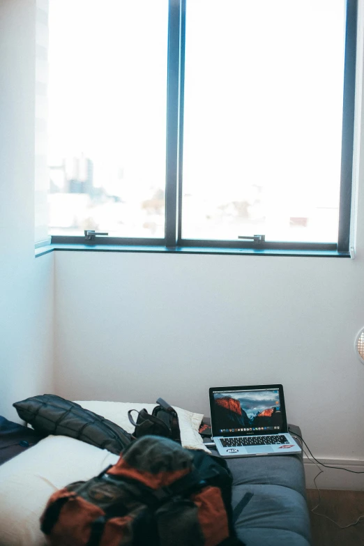 a laptop computer sitting on top of a bed, inspired by Elsa Bleda, happening, panorama shot, college, high res photograph, apartment