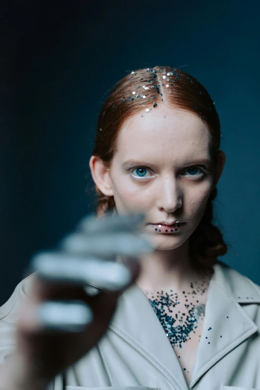 a close up of a person holding a cell phone, a portrait, by Adam Marczyński, renaissance, movie still of a cyborg, hr ginger, holding ego weapons, lily frank