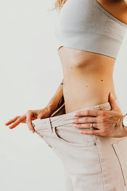 a woman standing with her hands in her pockets, trending on pexels, figuration libre, made of lab tissue, belly button showing, white bg, photo of a hand jewellery model