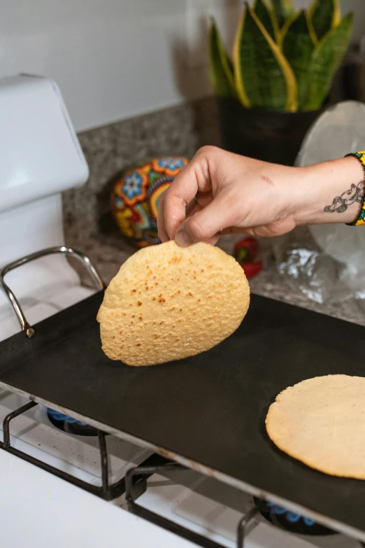 a person putting a tortilla on top of a pan, pancake short large head, hippie pad, frontal shot, sponge