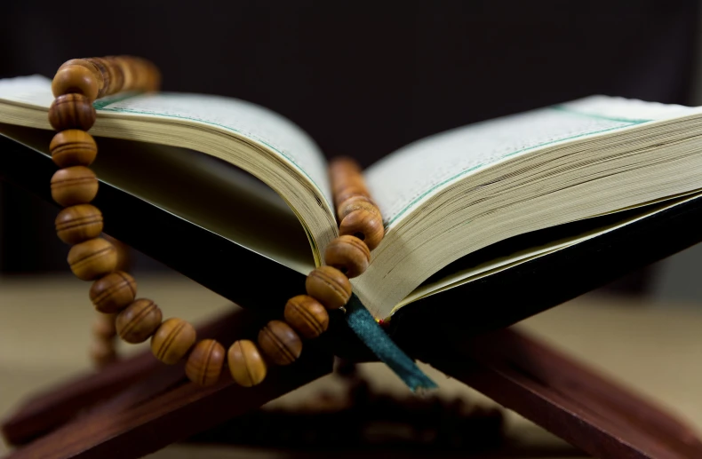 an open book sitting on top of a wooden stand, hurufiyya, doing a prayer, thumbnail, multiple stories, riyahd cassiem