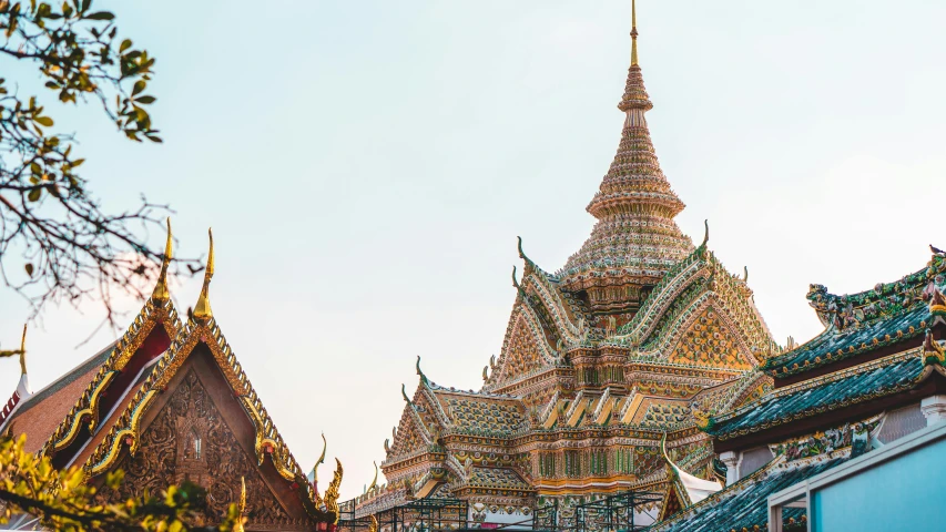 a group of people standing in front of a building, trending on unsplash, cloisonnism, thai architecture, black domes and spires, square, brown