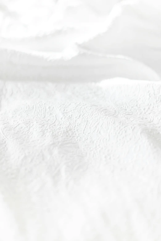 a close up of a white blanket on a bed, made of silk paper, with a white background, white: 0.5, embossed