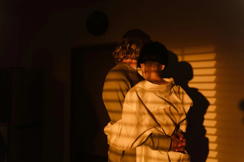 a couple of people standing next to each other, inspired by Nan Goldin, unsplash, visual art, lesbian embrace, no light penetrates to room, shadowed, ruan jia and brom