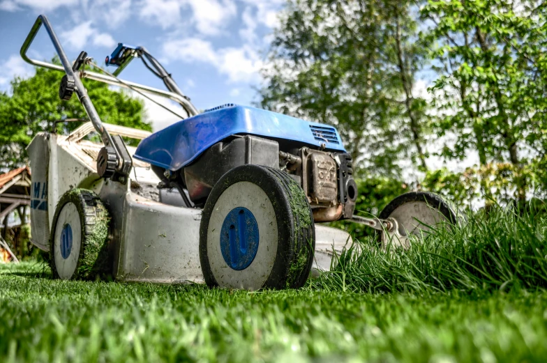 a blue and white lawn mower sitting on top of a lush green field, saws, thumbnail, highly polished, sitting in the garden