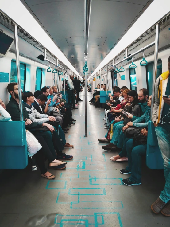 a group of people sitting on a train next to each other, futuristic sao paulo, teal electricity, real trending on instagram image, infinitely long corridors