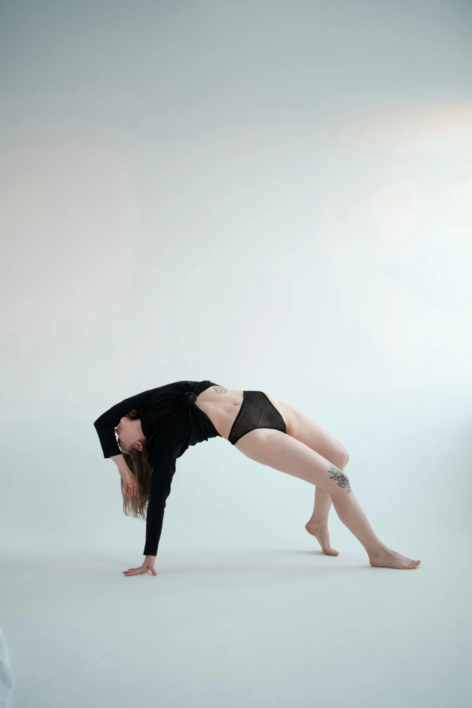 a woman doing a handstand pose in a studio, inspired by Elizabeth Polunin, julia hetta, low quality photo, bodysuit, pose 4 of 1 6