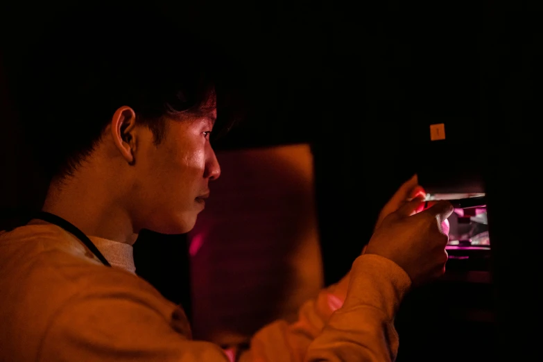 a close up of a person holding a cell phone, interactive art, 8 0 s asian neon movie still, studious chiaroscuro, shot with sony alpha 1 camera, scientist