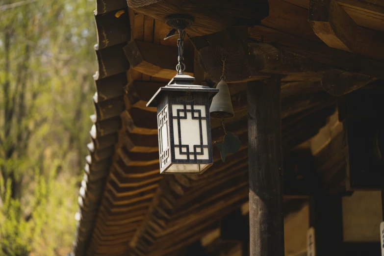 a lantern hanging from the side of a building, inspired by Gu An, unsplash, arts and crafts movement, square, traditional korean interior, cabin lights, low - angle shot