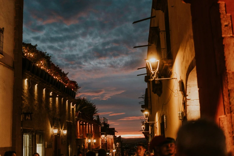 a group of people walking down a street at night, pexels contest winner, renaissance, tlaquepaque, sunset view, profile image, background image