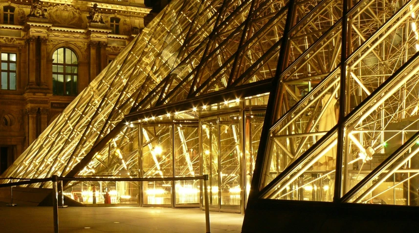 a couple of glass pyramids in front of a building, a photo, flickr, parisian street at night, gold and luxury materials, lightweight