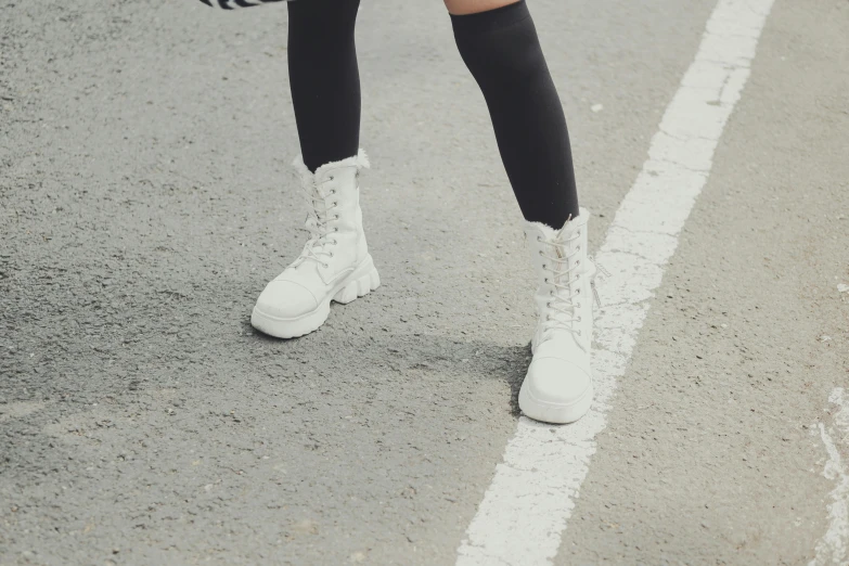 a woman standing on the side of a road, trending on pexels, platform boots, wearing white tights, fuzzy details, ulzzang