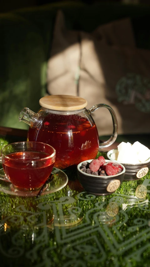 a glass tea pot sitting on top of a table, raspberry, thumbnail, rustic setting, hero shot