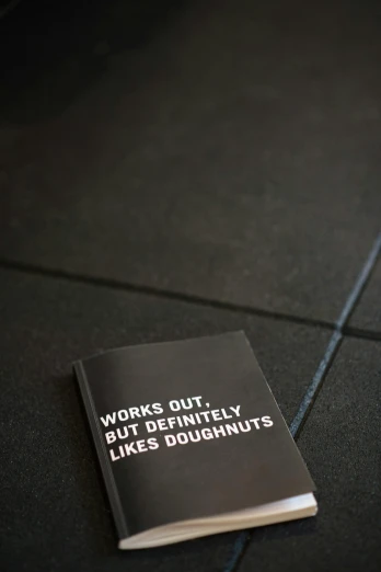 a book that is laying on the ground, unsplash, fluxus, donut, in a gym, matte black paper, ffffound