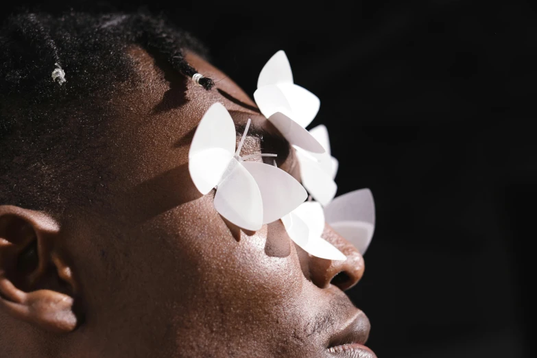 a woman with white flowers in her hair, inspired by Robert Mapplethorpe, trending on pexels, afrofuturism, butterfly lighting, light over boy, eyepatches, made from paper