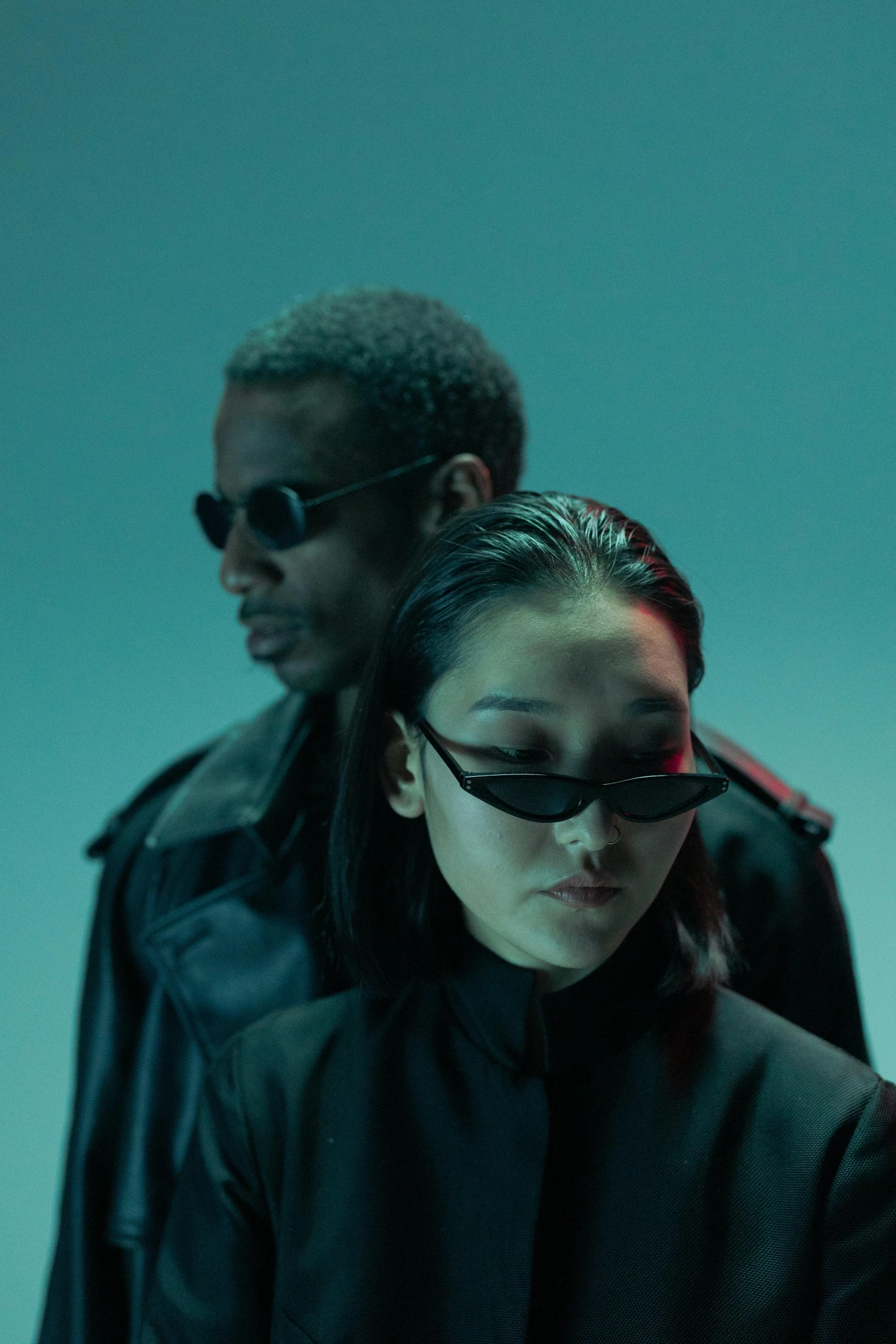 a couple of people standing next to each other, an album cover, inspired by Zhu Da, trending on pexels, technological sunglasses, matrix film color, high fashion, darker skin