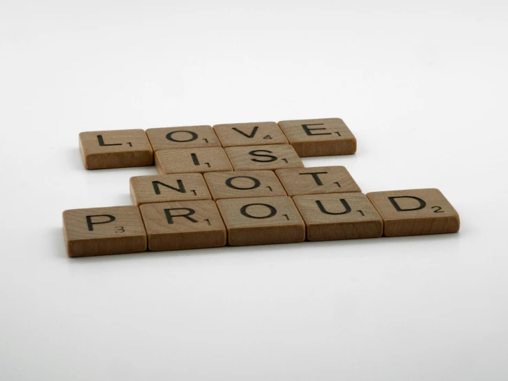 wooden scrabbles spelling love is not proud, inspired by Samuel Prout, pride, round-cropped, product photograph, proud