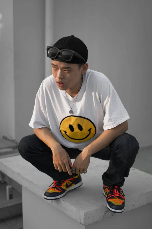 a man sitting on top of a cement block, a cartoon, inspired by Gang Hui-an, unsplash, minimalism, smiley face, short sleeves, wearing a patch over one eye, wearing a baggy