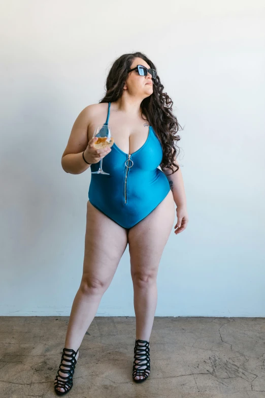 a woman in a blue bodysuit holding a glass of wine, by Nicolette Macnamara, unsplash, full figured, monokini, adult swim style, kailee mandel