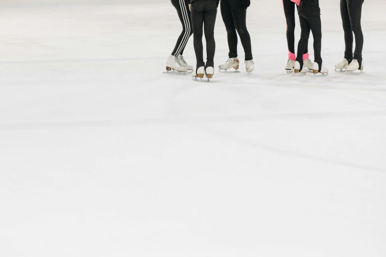 a group of people standing on top of a ice rink, trending on pexels, figuration libre, sleek legs, wearing a track suit, black on white, white and pink cloth