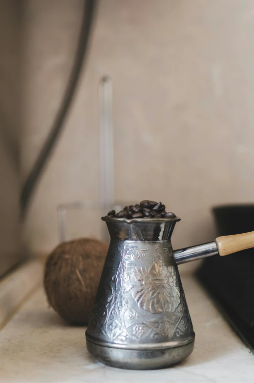 a silver coffee pot sitting on top of a counter, inspired by Ceferí Olivé, unsplash, renaissance, beans, rustic, turkey, black