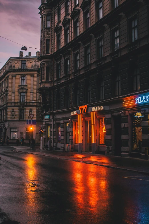 a street filled with lots of traffic next to tall buildings, by Adam Marczyński, pexels contest winner, at evening during rain, old shops, orange neon, calm evening